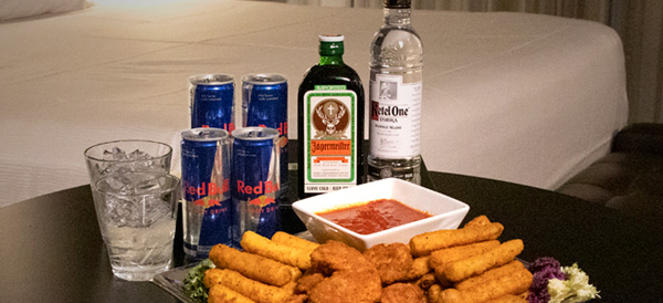 Table with mozzarella sticks and chicken tenders in front of Ketel One vodka, Jaegermeister, Red Bull, and ice water