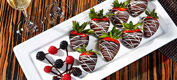 Chocolate covered strawberries on a white ceramic plate